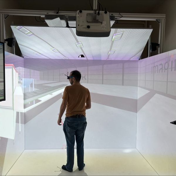 Un homme se tient debout face à plusieurs murs de projection immersive