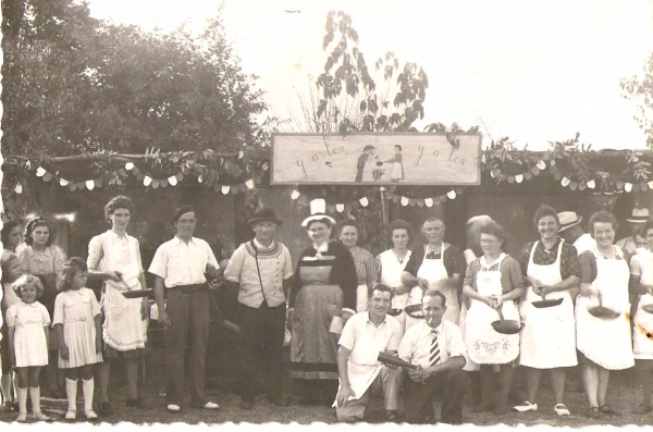 9. Parents et bénévoles devant un stand de kermesse, vers 1945