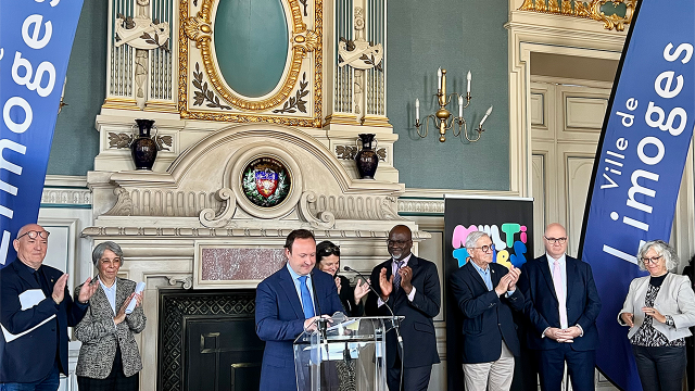Discours à l’Hôtel de Ville de Limoges, en présence d’élus et de partenaires institutionnels, autour d’un pupitre orné des bannières de la Ville de Limoges. Plusieurs intervenants se tiennent côte à côte et applaudissent.